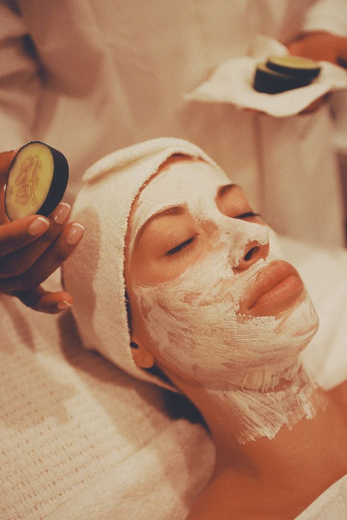 gallery-03 A woman receiving a rejuvenating facial mask at a spa, surrounded by soothing ambiance.
